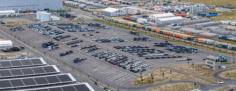Aerial view of Tesla Gigafactory Berlin Brandenburg showing rows of parked electric vehicles and transport trucks in the logistics yard in Grunheide Mark Brandenburg Germany. Aerial view of Tesla Gigafactory Berlin Brandenburg showing rows of parked electric vehicles and transport trucks in the logistics yard in Grunheide Mark Brandenburg Germany.