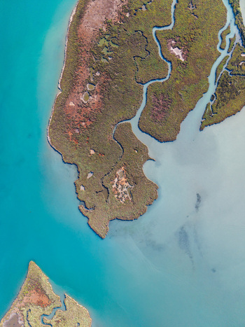 Aerial view of the Vivari Channel featuring winding waterways and marshland surrounded by turquoise waters in Sarande Vlore County Albania.
