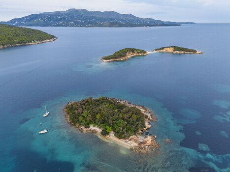 Aerial view of the Ksamil Islands in the Ionian Sea featuring lush green vegetation rocky shorelines turquoise waters and small boats anchored nearby in Ksamil Vlore County Albania. Aerial view of the Ksamil Islands in the Ionian Sea featuring lush green vegetation rocky shorelines turquoise waters and small boats anchored nearby in Ksamil Vlore County Albania.