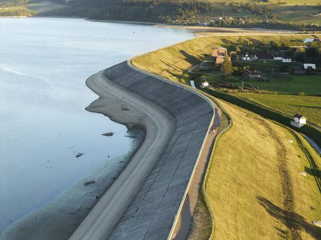 Aerial view of Lake Czorsztynskie dam with concrete embankment grassy slopes and rural landscape in Nowy Targ Lesser Poland Voivode Poland.