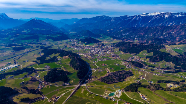 Aerial view of the valley floor s patchwork of green fields and dark forests leading to the town nestled amongst the mountains Windischgarsten Upper Austria Austria. Aerial view of the valley floor s patchwork of green fields and dark forests leading to the town nestled amongst the mountains Windischgarsten Upper Austria Austria.