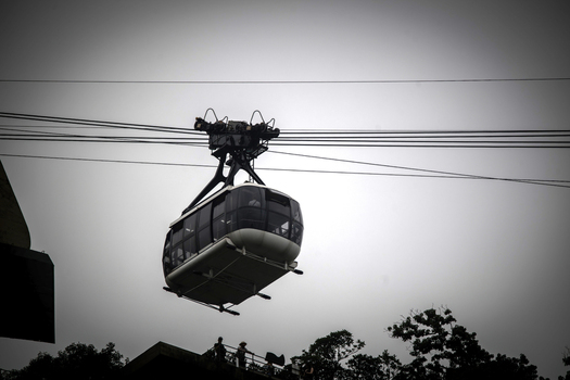 View of the Sugarloaf Mountain cable car suspended on thick steel cables against a grey overcast sky in Rio de Janeiro State of Rio de Janeiro Brazil.