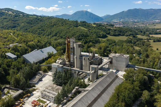 Aerial view of the Sacci S.P.A. cement factory surrounded by lush green hills and forests in Castelraimondo Marche Italy. Aerial view of the Sacci S.P.A. cement factory surrounded by lush green hills and forests in Castelraimondo Marche Italy.