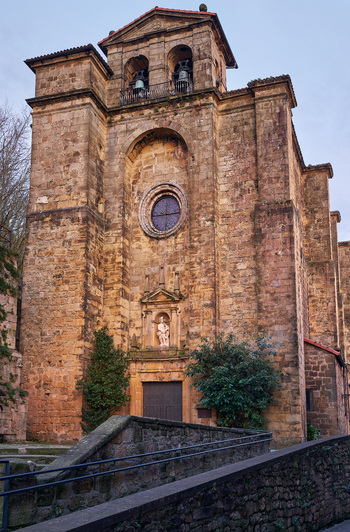 Pasai Donibane Spain 09 March 2026 View of the historic San Juan Bautista Church featuring its stone facade bell tower and ornate entrance under a clear sky.
