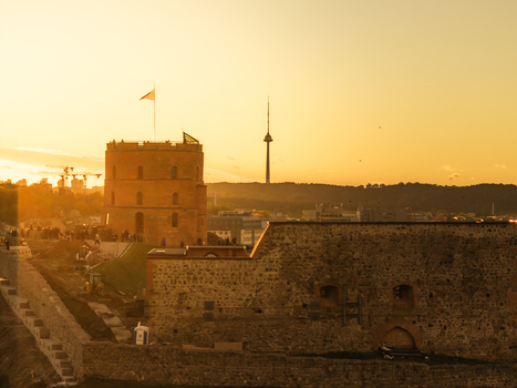 Aerial view of Gediminas Tower stands bathed in warm golden light with Vilnius TV Tower piercing the skyline behind ancient ramparts Vilnius Lithuania. Aerial view of Gediminas Tower stands bathed in warm golden light with Vilnius TV Tower piercing the skyline behind ancient ramparts Vilnius Lithuania.