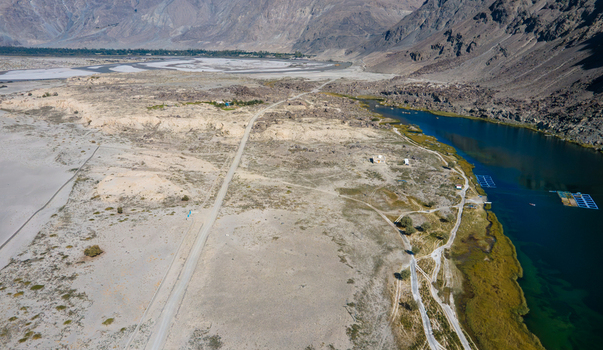 Aerial view of Blind Lake Sarfaranga Shigar featuring a winding road arid terrain and turquoise water surrounded by rugged mountains in Skardu Gilgit Pakistan. Aerial view of Blind Lake Sarfaranga Shigar featuring a winding road arid terrain and turquoise water surrounded by rugged mountains in Skardu Gilgit Pakistan.