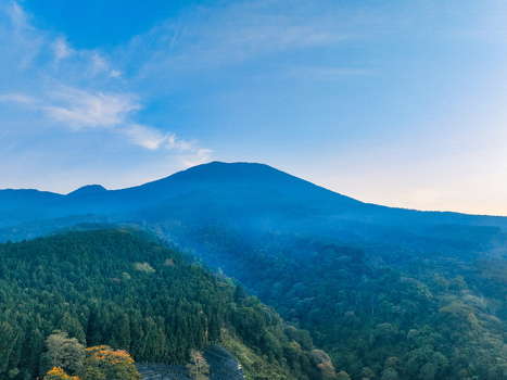 Aerial view of Goalpara Tea Park nestled at the foot of a lush mountain with dense forest slopes under a clear blue sky in Kecamatan Sukaraja Jawa Barat Indonesia. Aerial view of Goalpara Tea Park nestled at the foot of a lush mountain with dense forest slopes under a clear blue sky in Kecamatan Sukaraja Jawa Barat Indonesia.