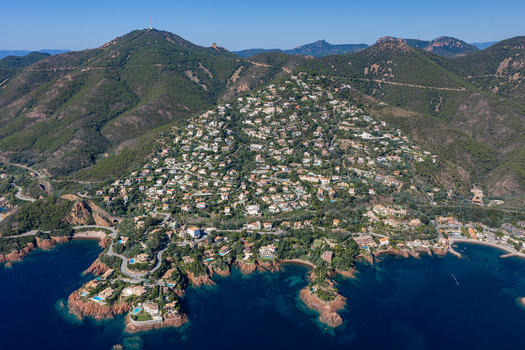 Aerial view of Le Trayas featuring hillside villas nestled among lush green forests overlooking the deep blue Mediterranean Sea in Saint Raphael Provence Alpes Cote d Azur France. Aerial view of Le Trayas featuring hillside villas nestled among lush green forests overlooking the deep blue Mediterranean Sea in Saint Raphael Provence Alpes Cote d Azur France.