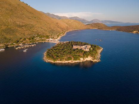 Aerial view of the historic stone castle on a lush green peninsula surrounded by the deep blue waters of the Ionian Sea in Porto Palermo Qarku i Vlores Albania. Aerial view of the historic stone castle on a lush green peninsula surrounded by the deep blue waters of the Ionian Sea in Porto Palermo Qarku i Vlores Albania.