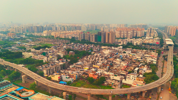 Aerial view of the metro rail track curving through the dense urban landscape with residential buildings and high rise apartments in Surat Gujarat India. Aerial view of the metro rail track curving through the dense urban landscape with residential buildings and high rise apartments in Surat Gujarat India.