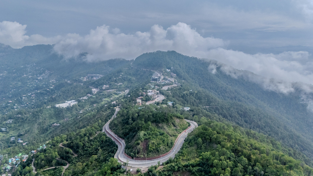Aerial view of Islamabad Murree Expressway winding through the lush green forested mountains under a cloudy sky in Lower Topa Punjab Pakistan. Aerial view of Islamabad Murree Expressway winding through the lush green forested mountains under a cloudy sky in Lower Topa Punjab Pakistan.