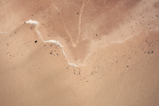 Aerial view of the textured sandy terrain and salt deposits of Detwah Lagoon with small rocks and ripples in the sand Qalansiyah wa Abd Al Kuri Socotra Yemen. Aerial view of the textured sandy terrain and salt deposits of Detwah Lagoon with small rocks and ripples in the sand Qalansiyah wa Abd Al Kuri Socotra Yemen.