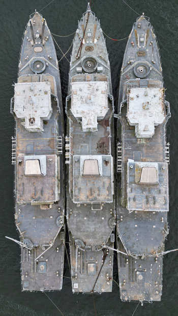 Aerial view of three ships moored together their weathered decks reflecting the muted light creating a stark contrast against the dark water Landévennec France. Aerial view of three ships moored together their weathered decks reflecting the muted light creating a stark contrast against the dark water Landévennec France.