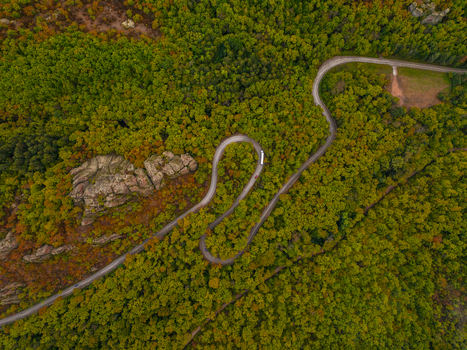 Aerial view of the winding road through the autumn forest and the unique rock formations of the Belogradchik Rocks in Belogradchik Vidin Bulgaria. Aerial view of the winding road through the autumn forest and the unique rock formations of the Belogradchik Rocks in Belogradchik Vidin Bulgaria.