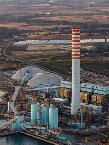 Aerial view of Centrale Termoelettrica Torrevaldaliga Nord power plant with its striped chimney storage domes and industrial infrastructure in Civitavecchia Lazio Italy. Aerial view of Centrale Termoelettrica Torrevaldaliga Nord power plant with its striped chimney storage domes and industrial infrastructure in Civitavecchia Lazio Italy.