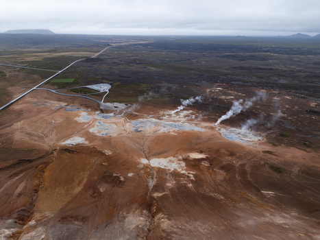 Aerial view of the Hverir geothermal area with steaming fumaroles and bubbling mud pools set against a barren volcanic landscape in Reykjahlid Thingeyjarsveit Iceland. Aerial view of the Hverir geothermal area with steaming fumaroles and bubbling mud pools set against a barren volcanic landscape in Reykjahlid Thingeyjarsveit Iceland.