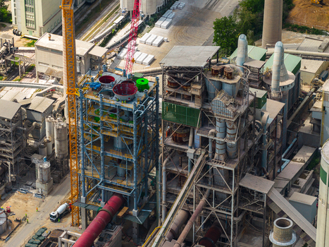 Aerial view of a large cement factory featuring industrial structures a yellow crane and a red rotary kiln in Mokra Horakov Jihomoravsky kraj Czechia. Aerial view of a large cement factory featuring industrial structures a yellow crane and a red rotary kiln in Mokra Horakov Jihomoravsky kraj Czechia.