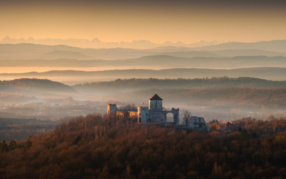 Aerial view of the Krakow Czestochowa Upland with a medieval castle ruin amidst misty forests and distant mountain peaks at sunset Krakow County Lesser Poland Voivode Poland. Aerial view of the Krakow Czestochowa Upland with a medieval castle ruin amidst misty forests and distant mountain peaks at sunset Krakow County Lesser Poland Voivode Poland.