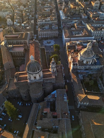 Aerial view of the Catania Cathedral and the historic city center with its Baroque architecture and terracotta rooftops during sunset in Catania Sicily Italy. Aerial view of the Catania Cathedral and the historic city center with its Baroque architecture and terracotta rooftops during sunset in Catania Sicily Italy.