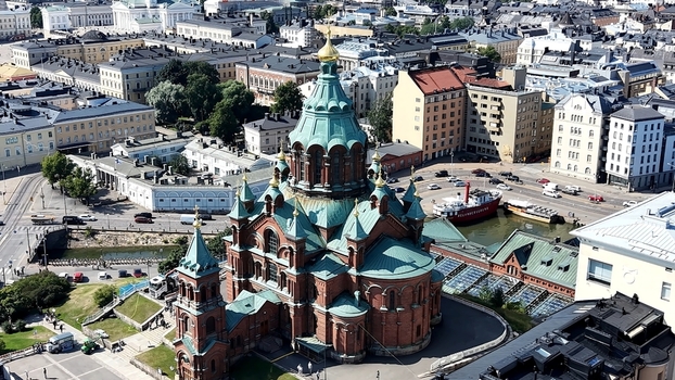 Aerial view of Uspenski Cathedral with its distinctive green domes and red brick facade surrounded by the historic urban cityscape and harbor of Helsinki Uusimaa Finland. Aerial view of Uspenski Cathedral with its distinctive green domes and red brick facade surrounded by the historic urban cityscape and harbor of Helsinki Uusimaa Finland.