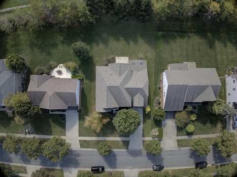 Aerial view of suburban houses with shingled roofs driveways and green lawns in a residential neighborhood in Mason Ohio United States.