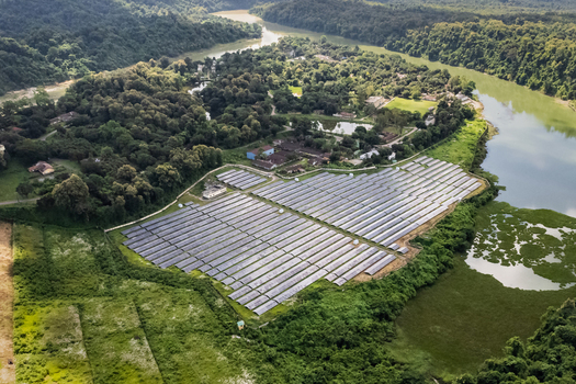 Kaptai Upazila Chittagong Division Bangladesh 06 September 2025 Aerial view of a solar farm situated near a river surrounded by dense tropical forest and lush greenery.
