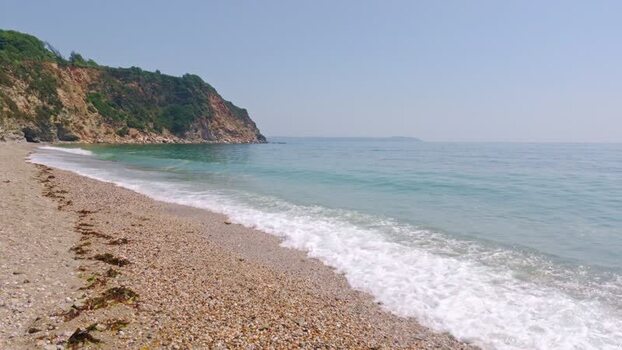View of the pebble beach and turquoise sea in Charlestown United Kingdom. View of the pebble beach and turquoise sea in Charlestown United Kingdom.