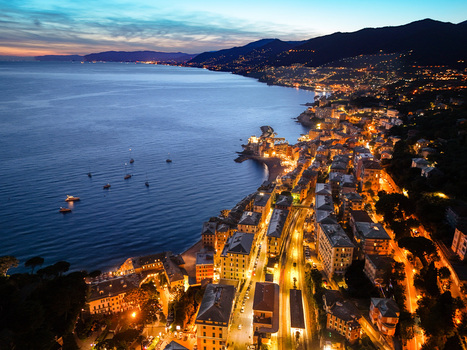 Aerial view of the illuminated coastal town of Camogli with its historic buildings harbor and boats on the Mediterranean Sea at dusk Camogli Liguria Italy. Aerial view of the illuminated coastal town of Camogli with its historic buildings harbor and boats on the Mediterranean Sea at dusk Camogli Liguria Italy.
