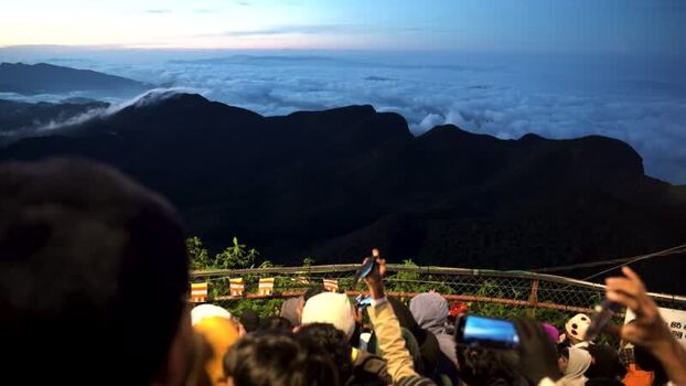 View of Adam s Peak summit with people watching sunrise Sri Lanka.