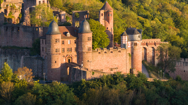 Aerial view of the historic Wertheim Castle with its red sandstone towers and walls surrounded by lush forest during golden hour in Wertheim Baden Wurttemberg Germany. Aerial view of the historic Wertheim Castle with its red sandstone towers and walls surrounded by lush forest during golden hour in Wertheim Baden Wurttemberg Germany.