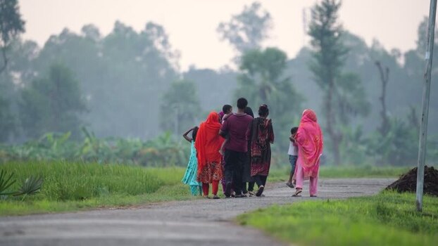 View of people walking on a rural road in Bogura Bangladesh.