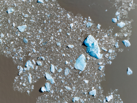Aerial view of icebergs and ice fragments floating in the dark waters of a glacier lagoon in Iceland. Aerial view of icebergs and ice fragments floating in the dark waters of a glacier lagoon in Iceland.
