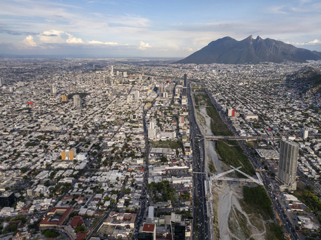 Aerial view of the sprawling urban landscape of Monterrey with the Santa Catarina River and the iconic Cerro de la Silla mountain in the background Monterrey Nuevo Leon Mexico.