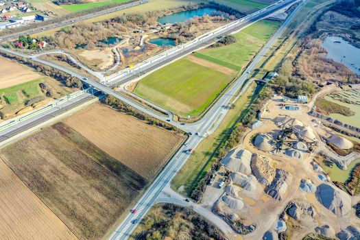 Aerial view of the highway and railway infrastructure near a construction site with small ponds and agricultural fields in Buttenheim Bavaria Germany. Aerial view of the highway and railway infrastructure near a construction site with small ponds and agricultural fields in Buttenheim Bavaria Germany.