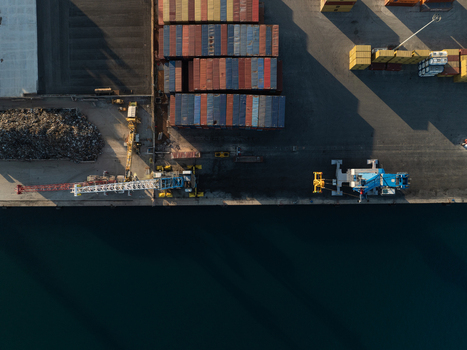 Aerial view of colorful shipping containers and industrial cranes at the port during sunset in Augusta Sicily Italy. Aerial view of colorful shipping containers and industrial cranes at the port during sunset in Augusta Sicily Italy.