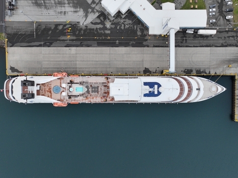 Aerial view of a large cruise ship docked at the pier in the harbor of Seydisfjordur Mulathing Iceland.