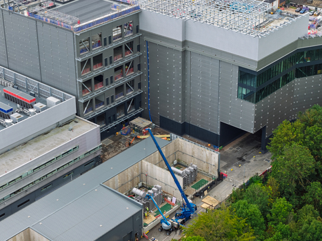 Aerial view of a large data center construction site with industrial buildings a blue crane and technical equipment in the United Kingdom.