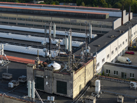 Aerial view of telecommunication towers and antennas installed on the rooftop of a large industrial building with HVAC units in Krakow Lesser Poland Voivode Poland.