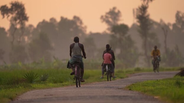 View of people riding bicycles on a rural road in Bogura Bangladesh.