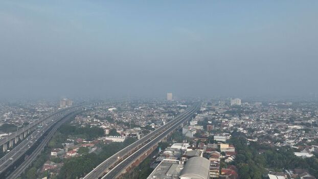 Aerial view of the elevated toll road winding through the dense urban landscape of Bekasi Barat West Java Indonesia. Aerial view of the elevated toll road winding through the dense urban landscape of Bekasi Barat West Java Indonesia.
