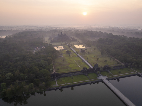 Aerial view of Angkor Wat temple complex at sunrise with misty surroundings and lush vegetation Krong Siem Reap Siem Reap Province Cambodia. Aerial view of Angkor Wat temple complex at sunrise with misty surroundings and lush vegetation Krong Siem Reap Siem Reap Province Cambodia.