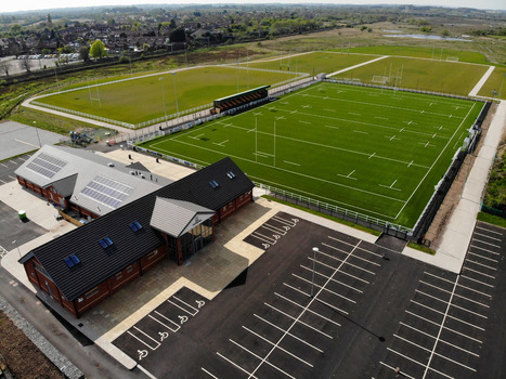 Stafford England United Kingdom 23 April 2020 Aerial view of Stafford Rugby Union Football Club with green rugby pitches a modern clubhouse and a paved parking area. Stafford England United Kingdom 23 April 2020 Aerial view of Stafford Rugby Union Football Club with green rugby pitches a modern clubhouse and a paved parking area.