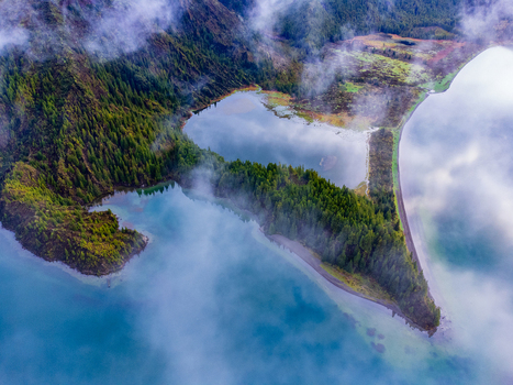 Aerial view of Lagoa do Fogo crater lake surrounded by lush green forests and misty clouds Agua de Alto Azores Portugal. Aerial view of Lagoa do Fogo crater lake surrounded by lush green forests and misty clouds Agua de Alto Azores Portugal.