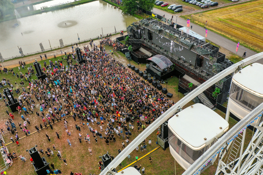 Herzogenaurach Germany 24 July 2025 Aerial view of the Open Beatz Festival featuring a large crowd gathered before a stage with ferris wheel gondolas in the foreground.