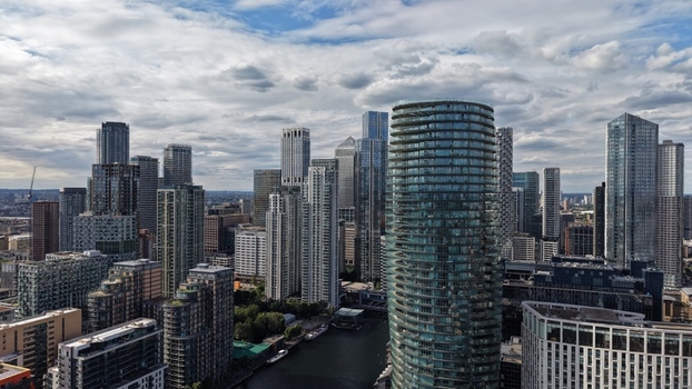 London United Kingdom 16 June 2026 Aerial view of Canary Wharf skyline featuring modern skyscrapers residential towers and the docklands under a dramatic cloudy sky.
