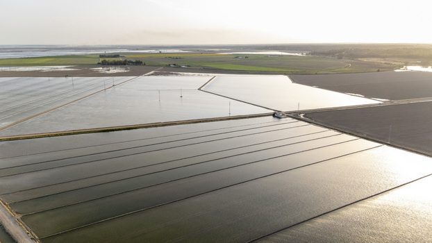 Aerial view of flooded rice fields at Isla Minima with geometric water patterns under a soft hazy sky in Coria del Rio Andalusia Spain. Aerial view of flooded rice fields at Isla Minima with geometric water patterns under a soft hazy sky in Coria del Rio Andalusia Spain.