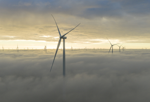 Aerial view of wind turbines emerging from a thick layer of fog in Netherlands. Aerial view of wind turbines emerging from a thick layer of fog in Netherlands.