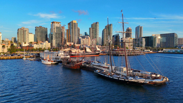 San Diego United States 01 April 2026 Aerial view of the San Diego skyline and waterfront featuring historic tall ships docked at the North Embarcadero under a clear blue sky.