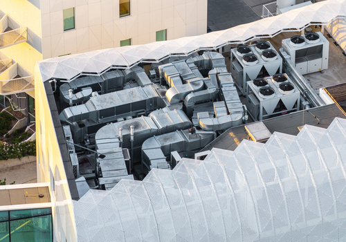 Aerial view of the modern medical resort rooftop with industrial HVAC ventilation ducts and cooling units integrated with white architectural mesh in Sopot Pomeranian Voivodeshi Poland. Aerial view of the modern medical resort rooftop with industrial HVAC ventilation ducts and cooling units integrated with white architectural mesh in Sopot Pomeranian Voivodeshi Poland.