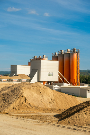 View of industrial silos and large piles of sand at a construction material facility under a clear blue sky Novi Sad Vojvodina Serbia. View of industrial silos and large piles of sand at a construction material facility under a clear blue sky Novi Sad Vojvodina Serbia.